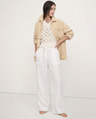 FJØRNA linen wide-leg women’s trousers with elastic waist and ruffle detail, showcasing soft, textured fabric and relaxed fit.