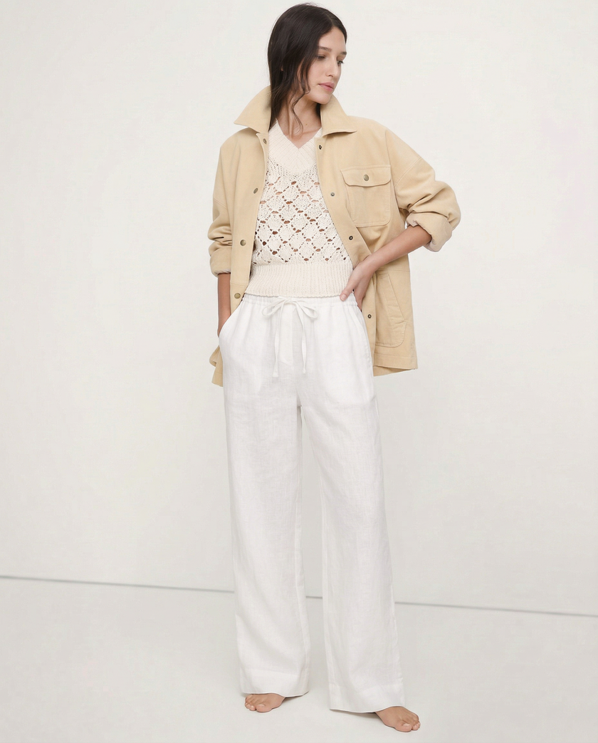 FJØRNA linen wide-leg women’s trousers with elastic waist and ruffle detail, showcasing soft, textured fabric and relaxed fit.