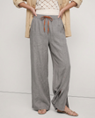 FJØRNA linen wide-leg women's trousers with drawstring, showcasing soft fabric and relaxed fit in a natural pose.