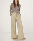 FJØRNA women's linen wide-leg trousers with elastic waist and ruffle detail, showcasing soft fabric and relaxed fit.