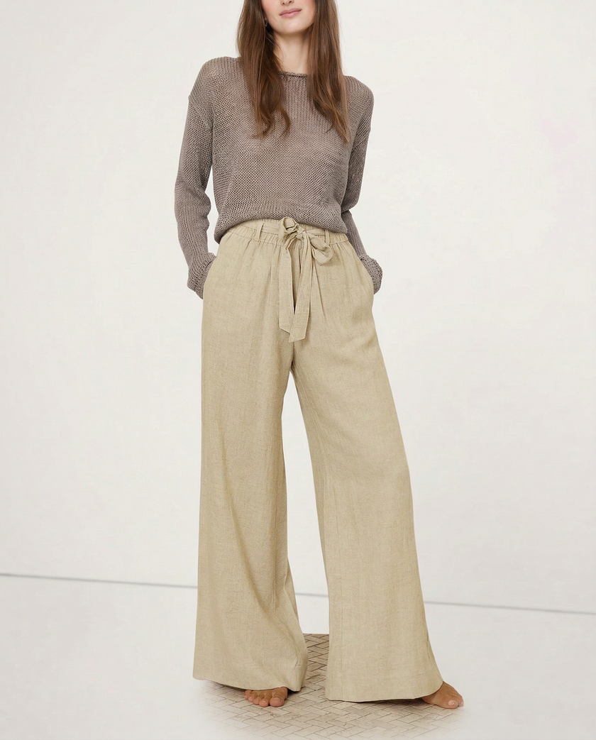FJØRNA women's linen wide-leg trousers with elastic waist and ruffle detail, showcasing soft fabric and relaxed fit.