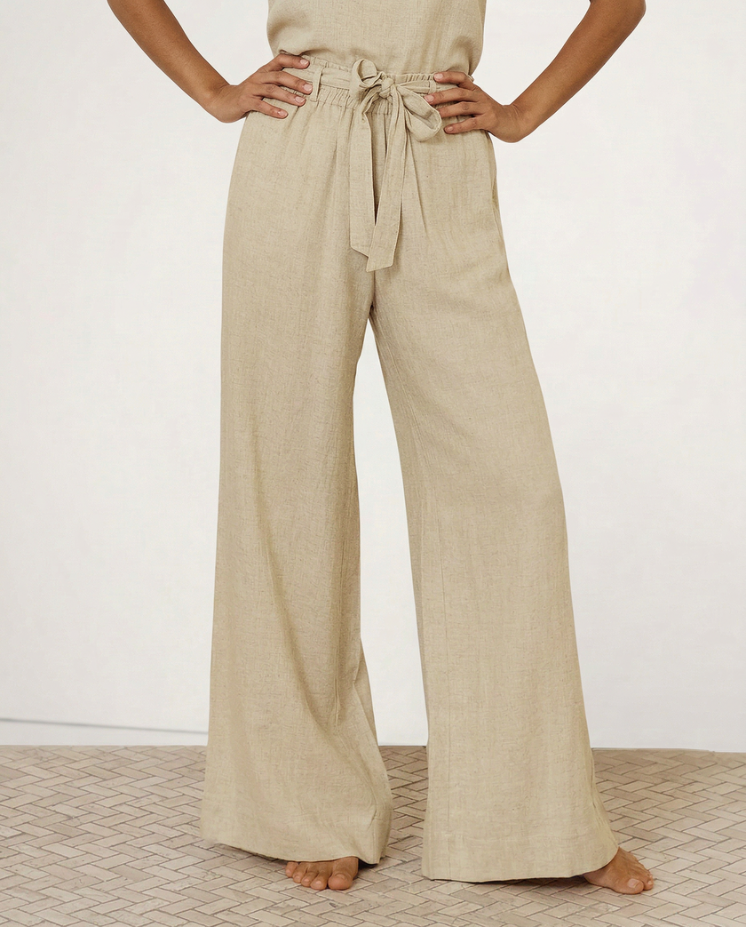 FJØRNA women's linen wide-leg trousers with elastic waist and ruffle details, showcasing soft fabric and relaxed fit.