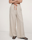 FJØRNA linen wide-leg women’s trousers with drawstring waist, showing soft fabric and relaxed fit in a bright, breathable design.