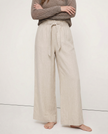 FJØRNA linen wide-leg women's trousers with elastic waist and ruffle details, showcasing soft fabric and relaxed fit.