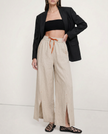 FJØRNA linen wide-leg women's trousers with drawstring, showing soft fabric and relaxed fit in a natural pose.