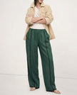 Women’s linen wide-leg trousers with elastic waist from FJØRNA, showcasing high-quality, realistic linen fabric and relaxed fit.