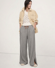 FJØRNA linen wide-leg women's trousers with drawstring waist, showing soft fabric and relaxed fit on a model.