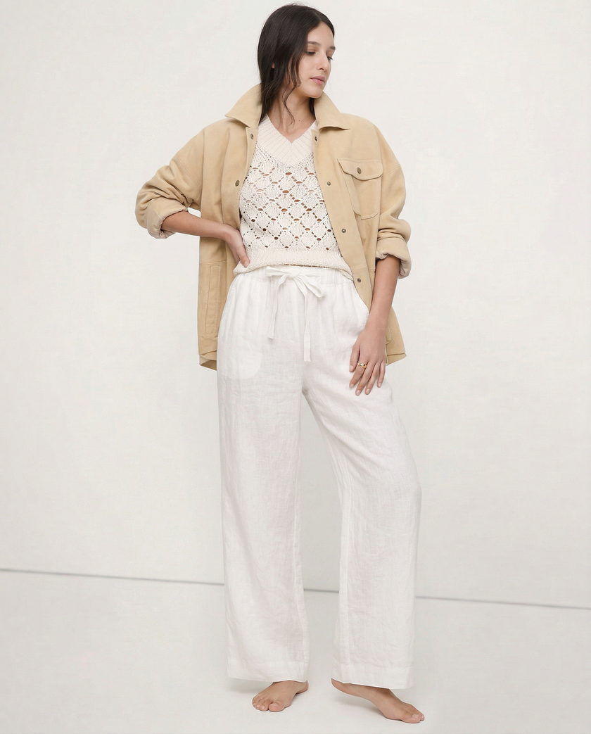 FJØRNA women's linen top with ruffle detail, showcasing lightweight fabric and stylish design in a natural outdoor setting.