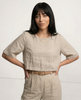FJØRNA women's linen crop top with short sleeves, lightweight and breathable, shown on a model in a casual setting.