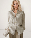 FJØRNA women's linen pleated shirt top worn by a model, featuring a relaxed fit and lightweight fabric for casual elegance.
