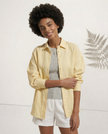 FJØRNA linen shirt with slit hem detail worn by a model, showcasing lightweight, relaxed fit and casual chic style.