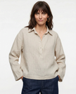 Women’s linen polo top with collar from FJØRNA, shown on a model, featuring a smooth, lightweight fabric and classic design.