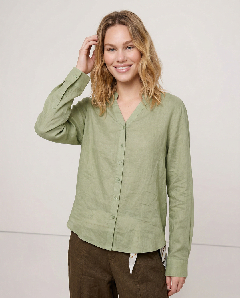 Women’s Linen Shirt V-Neck by FJØRNA, light and breathable top with a relaxed fit, worn by a model in a casual setting.