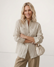FJØRNA women's linen pleated shirt, light and airy top with a relaxed fit, featuring pleats on the front and long sleeves.