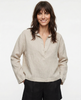FJØRNA linen polo top for women with a collar, shown on a model, featuring a relaxed fit and lightweight, breathable fabric.