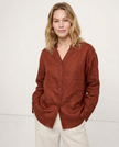 FJØRNA women's linen V-neck shirt, lightweight and breathable top, shown on a model in a casual outdoor setting.