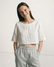 FJØRNA women's linen crop top with short sleeves, lightweight and breathable, worn by a model in a casual setting