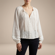 FJØRNA women's summer blouse with V-neck, long lace sleeves, and ruffle details, shown from the front.