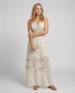 FJØRNA bohemian lace maxi dress with tiered skirt and tassel waist, full-length front view showing intricate lace details and flowing fabric.