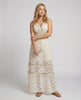 FJØRNA bohemian lace maxi dress with tiered skirt and tassel waist, full-length front view showing intricate lace details and flowing fabric.