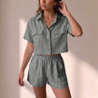 FJØRNA relaxed 2-piece shorts set in gray textured woven fabric with collared top and matching shorts, casual and lightweight style.