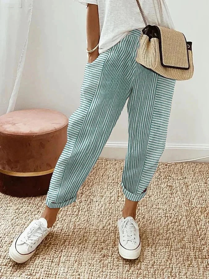 FJØRNA Holly™ striped green pants with a relaxed fit and bold pattern, styled with a casual top and sneakers for a trendy look.