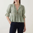 Green FJØRNA women's summer blouse with V-neck, puff sleeves, and lace details, perfect for warm-weather stylish outfits.