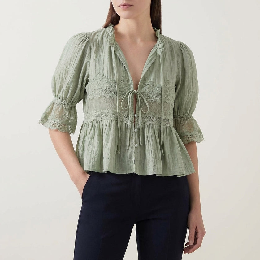 Green FJØRNA women's summer blouse with V-neck, puff sleeves, and lace details, perfect for warm-weather stylish outfits.