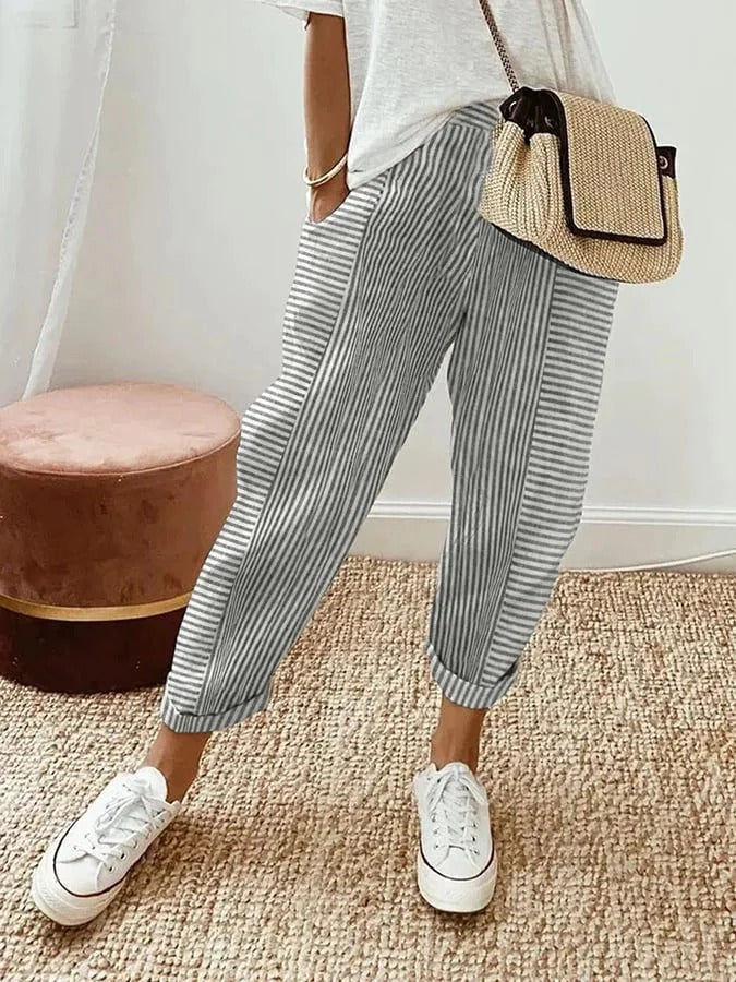 FJØRNA Holly™ striped grey pants with a relaxed fit, featuring horizontal grey and white stripes and an elastic waistband.