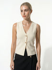 FJØRNA women's sleeveless structured waistcoat with tailored layering, shown with hands adjusting the fit.