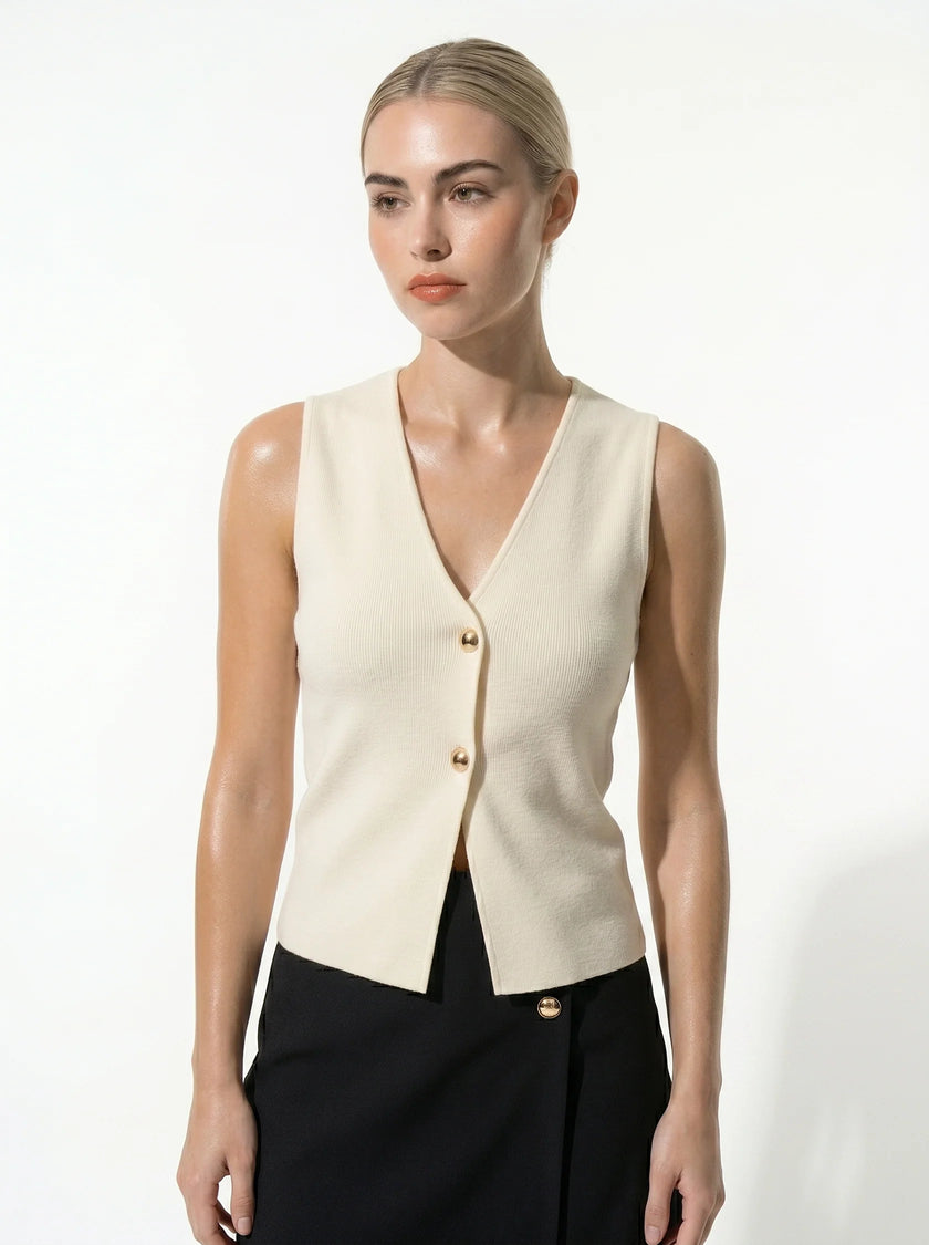 FJØRNA women's sleeveless structured waistcoat with tailored layering, shown with hands adjusting the fit.