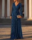 FJØRNA shimmering long-sleeve V-neck wrap evening gown, elegant maxi dress with flowing fabric and stylish sleeves.