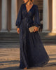 FJØRNA shimmering long-sleeve V-neck wrap evening gown, elegant maxi dress with sleeves, in a flowing, glamorous style.