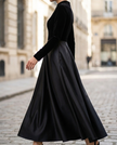 FJØRNA elegant black velvet and satin midi dress for women, showcasing a fitted silhouette with a stylish neckline and sleek fabric.