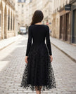 Black FJØRNA stretch knit dress with 3D floral embroidered mesh overskirt, showcasing elegant floral design and fitted silhouette.