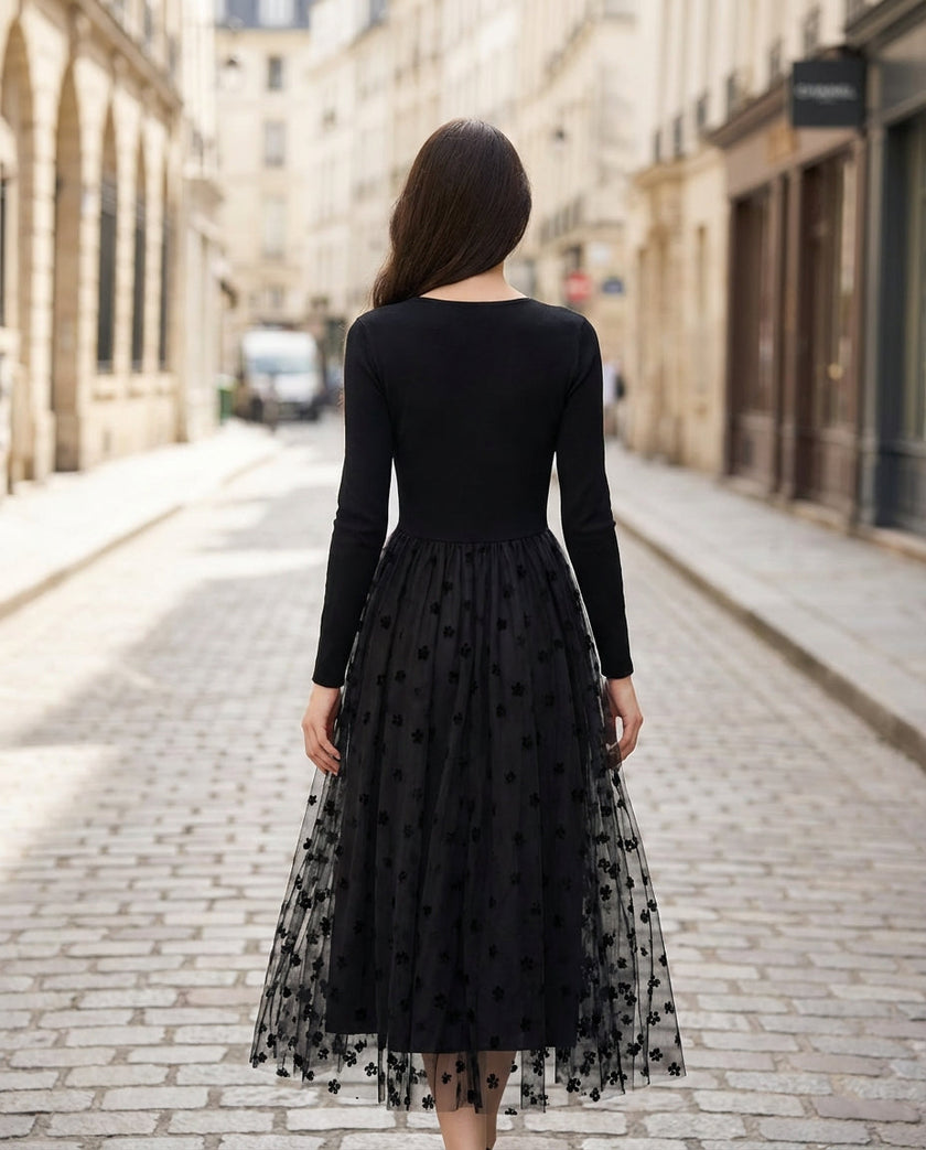 Black FJØRNA stretch knit dress with 3D floral embroidered mesh overskirt, showcasing elegant floral design and fitted silhouette.