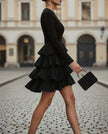 FJØRNA high-neck long-sleeve tiered ruffle mini dress for women, featuring layered ruffles and a fitted silhouette.