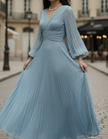 Steel blue pleated midi dress by FJØRNA featuring a flowing silhouette, pleats, and a stylish midi length perfect for elegant occasions.