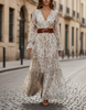 FJØRNA romantic floral chiffon maxi dress with belted waist, flowing fabric, and vibrant floral pattern.