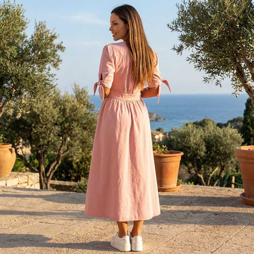 FJØRNA button front midi dress with V-neck and waist tie, shown hanging on a hanger against a neutral background.