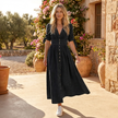 FJØRNA button front midi dress with V neck and waist tie, shown in a natural pose, highlighting the dress's flowy fabric and stylish details.