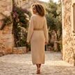 FJØRNA ribbed knit midi dress with long sleeves and high neck, shown in a close-up of the textured fabric and fitted silhouette.