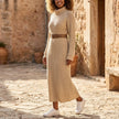 FJØRNA ribbed knit midi dress with long sleeves and high neck, shown on a model in a neutral setting.
