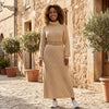 FJØRNA ribbed knit midi dress with long sleeves and high neckline, showcasing a fitted, stylish design on a model.