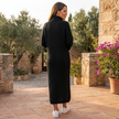 FJØRNA ribbed knit midi dress with long sleeves and high neckline, showcasing a fitted design and textured fabric.