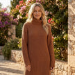 FJØRNA ribbed knit midi dress with long sleeves and high neck, shown on a model in a neutral setting.
