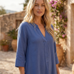 FJØRNA loose fit maxi shirt dress with long sleeves and V-neck, shown hanging with a relaxed, flowing silhouette.