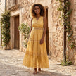 FJØRNA tiered lace maxi dress with V-neck and flowing skirt, featuring intricate lace details and elegant design.