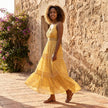 FJØRNA tiered lace maxi dress with V-neck and flowing skirt, shown in a full-length view highlighting its elegant design.