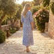 Printed V-neck midi dress with relaxed fit by FJØRNA, showing a flowy silhouette and detailed print fabric.